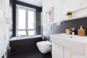 łazienka z toaletą, umywalką i oknem w obiekcie Pineapple Apartments Dresden Zwinger IV - 65 qm - 1x free parking w Dreźnie