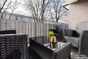 a patio with chairs and a table and a fence at PINEAPPLE APARTMENTS - Zwinger IV - 65qm - 1x free parking in Dresden +9 photos