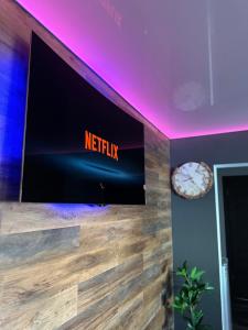 a tv on a wall with a netflix sign on it at Apartamente A&A in Târgu Ocna