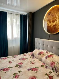 a bedroom with a bed with flowers on it at Apartamente A&A in Tîrgu Ocna
