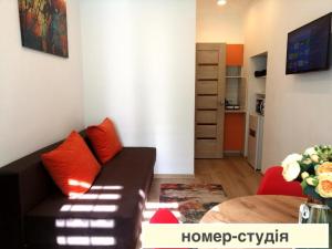 a living room with a black couch and red pillows at Apartments in the city center in Lviv