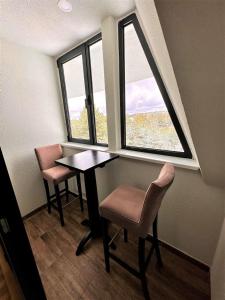 a room with a table and two chairs and a window at Lexi Bombonjera apartman in Divčibare