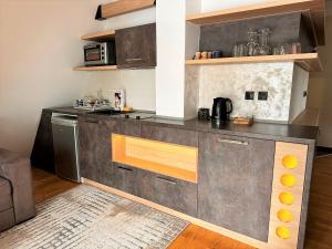 a kitchen with a gray counter top in a room at Lexi Bombonjera apartman in Divčibare