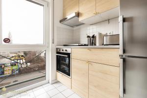 cocina con nevera de acero inoxidable y ventana en Pineapple Apartments Dresden Mitte III - free parking en Dresden