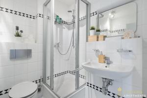 a white bathroom with a shower and a sink at Pineapple Apartments Dresden Mitte III - free parking in Dresden