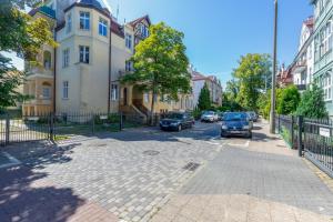 a street with cars parked in front of buildings at TOTU HOME Seaside Sopot Helska Apartment in Sopot