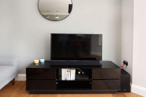 a black entertainment center with a flat screen tv at Comfy 1 bed flat in Tufnell Park in London