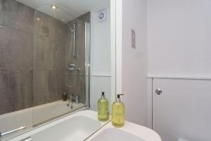 dos botellas sentadas en un lavabo en un baño en Comfy 1 bed flat in Tufnell Park, en Londres