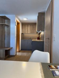 a kitchen with wooden cabinets and a counter top at Modernes Studio Zermatt in Zermatt