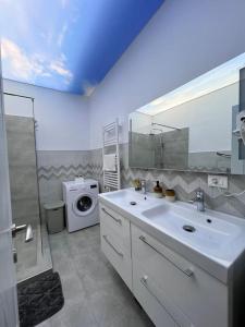 a bathroom with a sink and a washing machine at Apartament la mare Lamera Residence in Năvodari