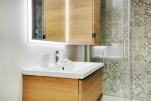 bagno con lavandino bianco e doccia di CMG Ramey / Sacré-Coeur III a Parigi