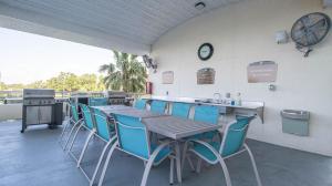 patio ze stołem, krzesłami i zegarem w obiekcie Ocean Club 701 w mieście Biloxi