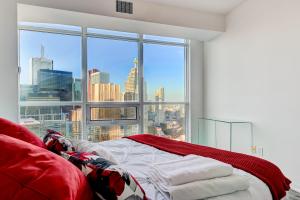 a bedroom with a view of a city from a window at Specious LUX 2BD Downtown Toronto with Parking! in Toronto