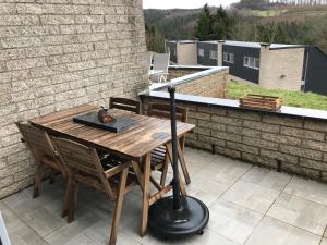 une table et des chaises en bois sur une terrasse dans l'établissement Terrasse de Malmedy 348, à Malmedy