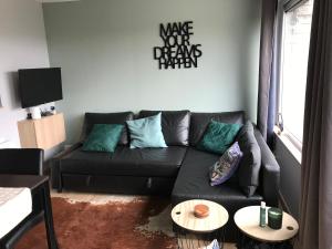 un salon avec un canapé noir et une table dans l'établissement Terrasse de Malmedy 348, à Malmedy