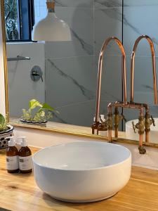 un lavabo à bol blanc et deux robinets sur un comptoir dans l'établissement Featherstone View Cottage, à Grahamstown