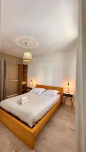 een slaapkamer met een groot bed met witte lakens bij Villeurbanne • T2 Fraternité • HostisY in Villeurbanne