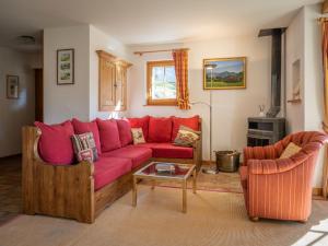 sala de estar con sofá rojo y 2 sillas en Chalet Six des Armailles by Interhome, en Ovronnaz