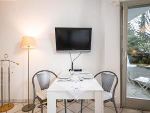 a white table with chairs and a tv on a wall at Apartment Appartement A12 by Interhome in Traben-Trarbach