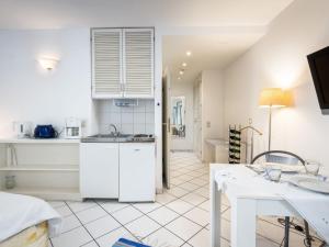 a white kitchen with a sink and a table at Apartment An der Mosel by Interhome in Traben-Trarbach