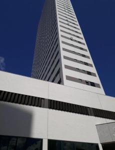 a tall white building with a blue sky in the background at Beach Class Ilha do Leite 2606 in Recife