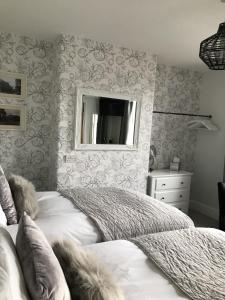 1 dormitorio con cama y espejo en la pared en The Glastonbury Townhouse B&B en Glastonbury