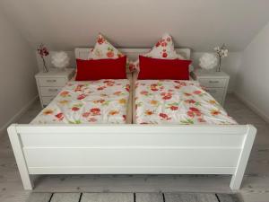 białe łóżko z czerwonymi poduszkami w sypialni w obiekcie Holiday Home Reissmann by Interhome w mieście Norden