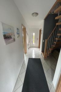 korytarz ze schodami i czarnym dywanem na podłodze w obiekcie Holiday Home Reissmann by Interhome w mieście Norden
