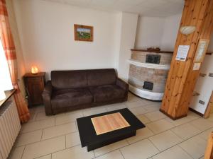 ein Wohnzimmer mit einem Sofa und einem Kamin in der Unterkunft Apartment Santa Lucia-3 by Interhome in Valdisotto