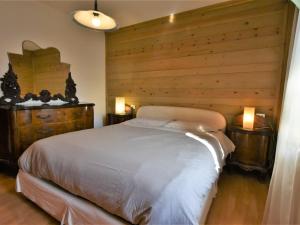 Schlafzimmer mit einem weißen Bett und Holzwänden in der Unterkunft Apartment Santa Lucia-3 by Interhome in Valdisotto