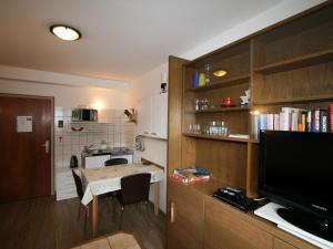 eine kleine Küche mit einem kleinen Tisch und einem TV in der Unterkunft Apartment Biegel-Kraus by Interhome in Steinach am Brenner