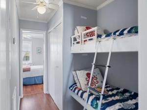 a room with two bunk beds and a bedroom at Breezy Does It - Take it "br-eezy" while you stay in the heart of Carolina Beach, One minute walk to the beach! condo in Carolina Beach