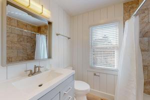 a bathroom with a sink and a toilet and a mirror at Windy Dunes 138 in Avon +21 photos