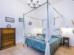 a bedroom with a canopy bed and a dresser at Apartment Serena by Interhome in Montecatini Val di Cecina