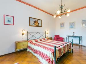 een slaapkamer met een bed en een rode stoel bij Apartment Serena by Interhome in Montecatini Val di Cecina