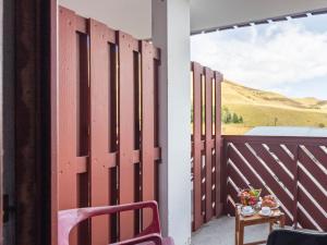 a wooden fence on a balcony with a table at Apartment Les Mousquetons-20 by Interhome in La Toussuire