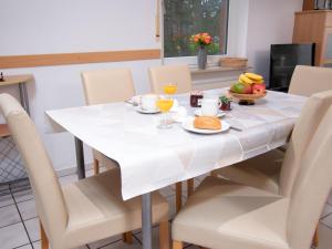 a white dining room table with chairs and a white tablecloth at Holiday Home Robbe by Interhome in Norddeich +34 photos