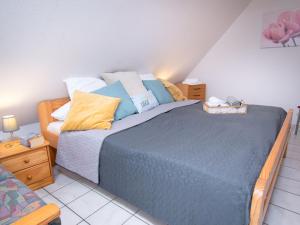 a bedroom with a bed with blue sheets and pillows at Holiday Home Robbe by Interhome in Norddeich