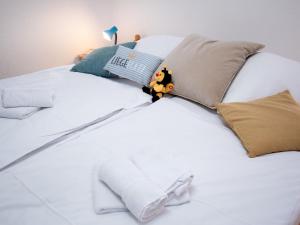 ein weißes Bett mit einem Stofftier darauf in der Unterkunft Apartment Windrose by Interhome in Norddeich