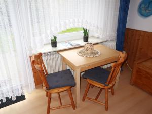 einen kleinen Tisch mit zwei Stühlen und einem Fenster in der Unterkunft Apartment Rosengrund by Interhome in Büsum