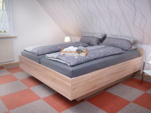 ein Bett mit einem Holzrahmen in einem Zimmer in der Unterkunft Apartment Schonerweg by Interhome in Norddeich