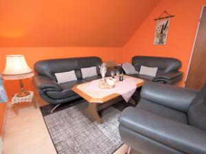 a living room with two leather chairs and a table at Apartment Schonerweg by Interhome in Norddeich