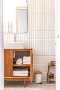 a bathroom with a sink and a shelf with towels at Suites 23 in Cassis