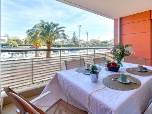 ein Esszimmer mit einem Tisch und einem großen Fenster in der Unterkunft Apartment Le 4 Mats-1 by Interhome in Fréjus