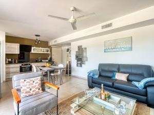 ein Wohnzimmer mit einem Sofa und einem Tisch in der Unterkunft Apartment Le 4 Mats-1 by Interhome in Fréjus