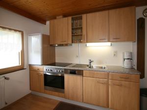 een keuken met houten kasten en een wastafel bij Apartment Neumann - FBZ202 by Interhome in Finkenberg