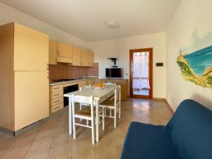 a kitchen with a white table and a white refrigerator at Apartment Tanca della Torre by Interhome in Isola Rossa