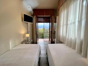two beds in a room with a window with a view at Villa Allende in Forte dei Marmi