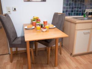 einen Holztisch mit Speisen und Getränken in der Küche in der Unterkunft Apartment Düne by Interhome in Norddeich