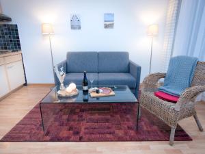 ein Wohnzimmer mit einem blauen Sofa und einem Tisch in der Unterkunft Apartment Düne by Interhome in Norddeich